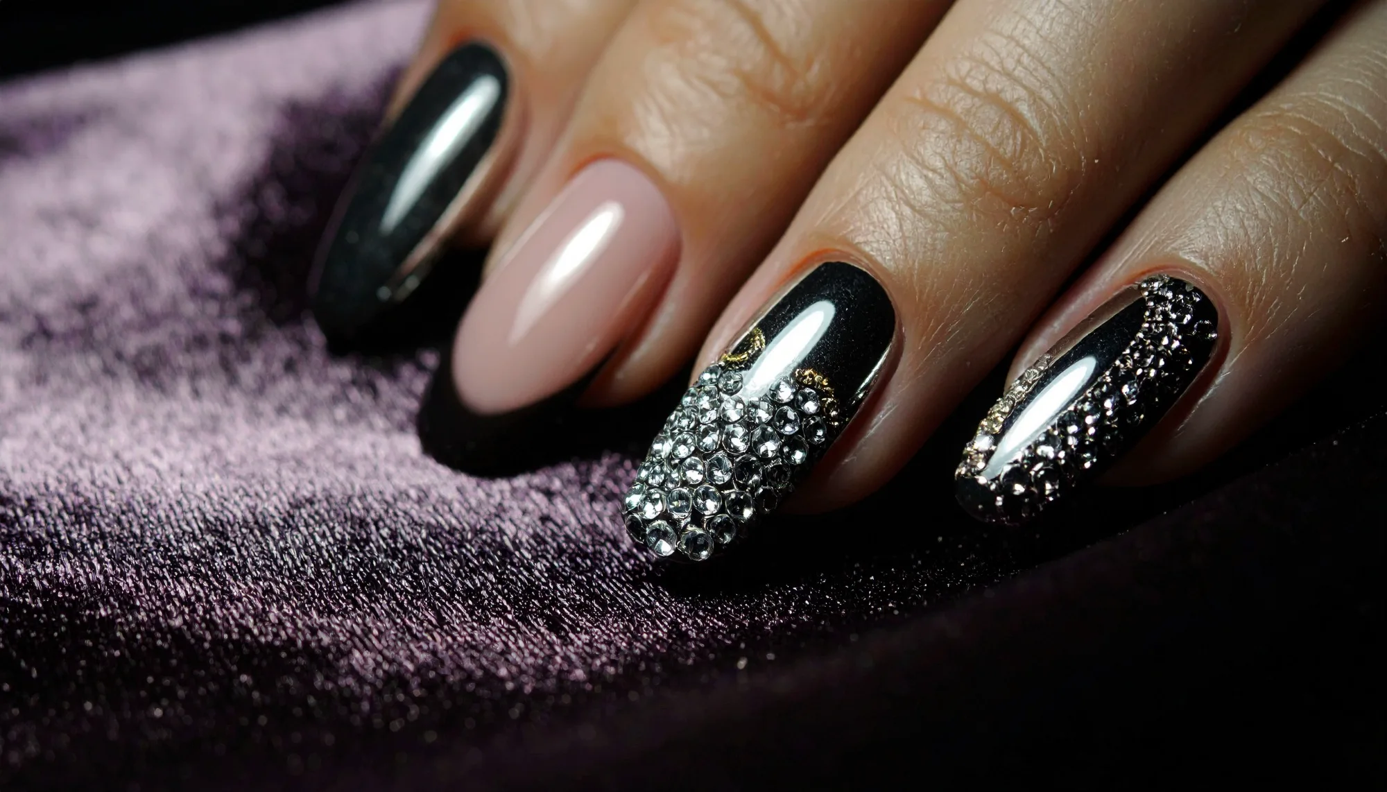 Evening-detail manicure with black chrome, crystals, and glossy contrast