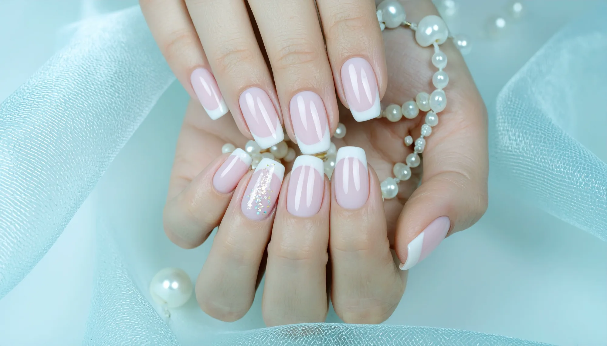 Pearl French manicure with blush pink polish and pearl styling on satin fabric